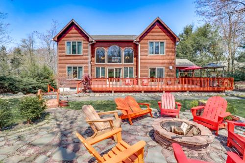a house with chairs and a fire pit in front of it at Fire Pit and BBQ Elegant Split Rock Resort Getaway! in Lake Harmony