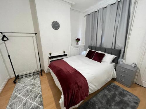 - une chambre avec un grand lit blanc et des oreillers rouges dans l'établissement Hometel Nice Comfy Apartment Can Sleep 10, à Leicester