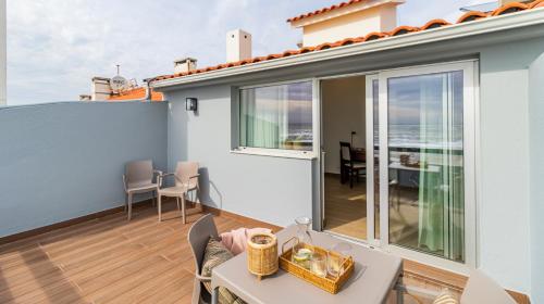 a balcony with a table and a dining room at Albergaria Quim Barreiros in Vila Praia de Âncora