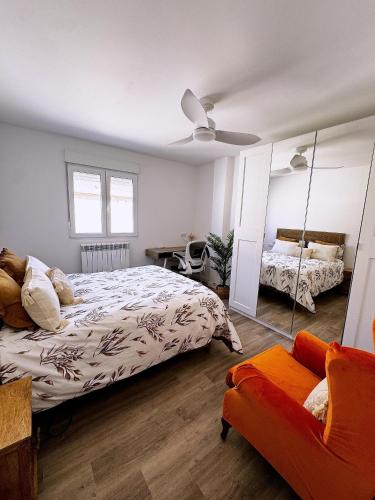 1 dormitorio con cama, espejo y sofá en Moderno Piso en Puerto Sagunto, en Puerto Sagunto