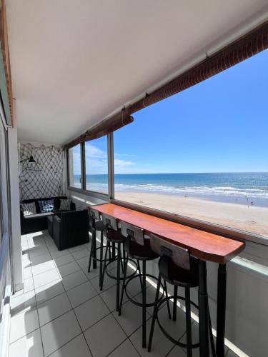 - une table avec des chaises et une vue sur la plage dans l'établissement face mer, à Saint-Hilaire-de-Riez