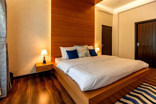 a bedroom with a large bed with a wooden headboard at Rahta Villa An elegant 3BR Villa & BBQ Terrace in Dehradun