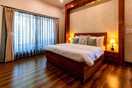 a bedroom with a large bed and a large window at Rahta Villa An elegant 3BR Villa & BBQ Terrace in Dehradun