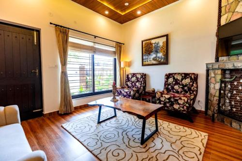 a living room with a table and chairs and a fireplace at Rahta Villa An elegant 3BR Villa & BBQ Terrace in Dehradun