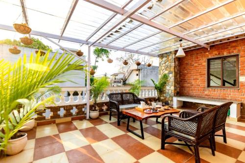 a conservatory with a table and chairs on a patio at Rahta Villa An elegant 3BR Villa & BBQ Terrace in Dehradun