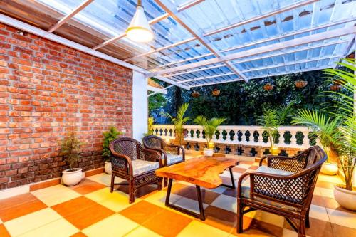 a patio with chairs and a table and a glass roof at Rahta Villa An elegant 3BR Villa & BBQ Terrace in Dehradun