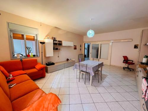 een woonkamer met een oranje bank en een tafel bij Quadrifoglio in Adrano
