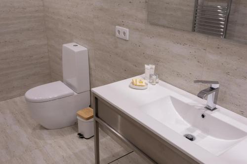 a bathroom with a white sink and a toilet at Quinta Carolina in Póvoa de Lanhoso