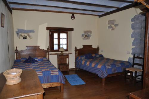 a bedroom with two beds and a table and a window at Etxeberri Landa Etxea in Errezil