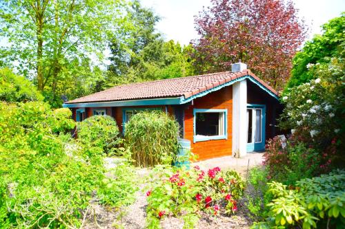 a small house in the middle of a garden at Sfeervol houten huis I Bosrijk Veluwe in Putten