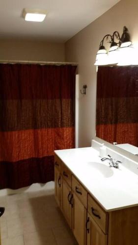 a bathroom with a sink and a shower curtain at Minocqua Lake Condo B7 in Minocqua