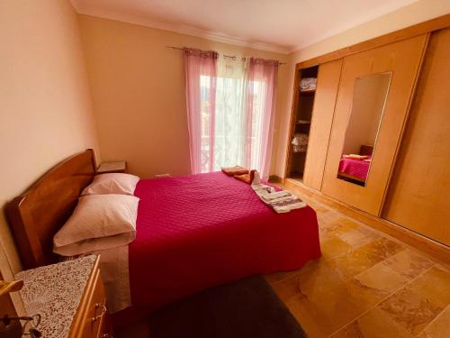 a bedroom with a red bed and a mirror at Belle Vue in São Jorge