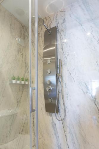 a shower stall in a bathroom with marble walls at AG Salinas 9 in Playa de Gandia