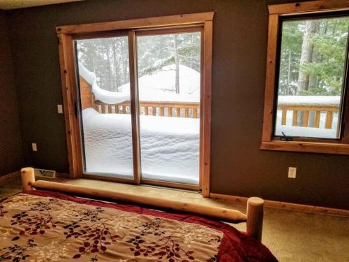 a bedroom with a bed and a window with snow outside at Minocqua Lake Condo B10 in Minocqua