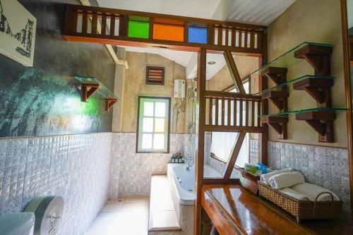 La salle de bains est pourvue d'un lavabo et de toilettes. dans l'établissement Chiang Mai Las Orquideas Resort, à Chiang Mai