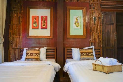 - une chambre avec 2 lits et 2 photos sur le mur dans l'établissement Chiang Mai Las Orquideas Resort, à Chiang Mai