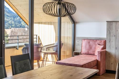 a living room with a chair and a table at Alpen Krone by Maier - Dornbirn in Dornbirn