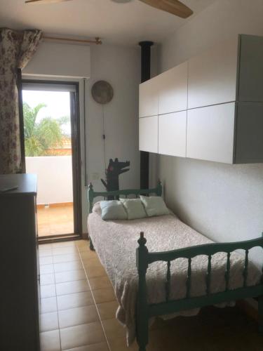 a bedroom with a bed and a sliding glass door at Dúplex con vistas panorámicas in Calabardina