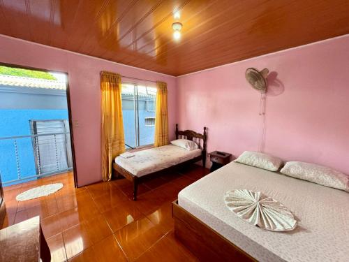 a bedroom with two beds and a window at Cabinas Las Palmas del Sol in Fortuna