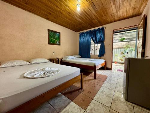 a bedroom with two beds and a window at Cabinas Las Palmas del Sol in Fortuna