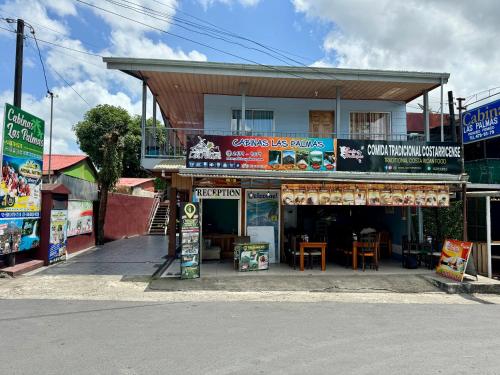 a store on the side of a street with a building at Cabinas Las Palmas del Sol in Fortuna