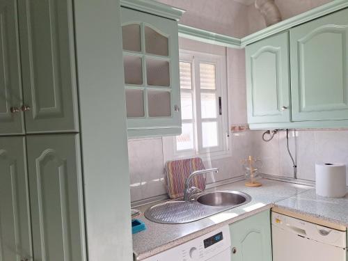 a kitchen with green cabinets and a sink at La sierra in Algar