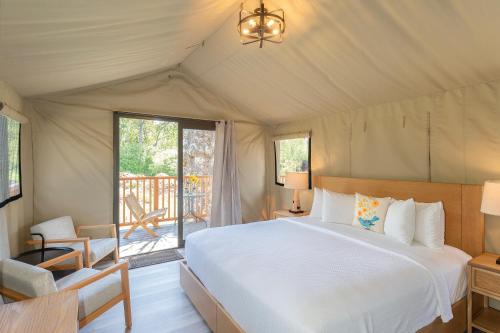 a bedroom with a large bed and a balcony at Carmel River Inn in Carmel