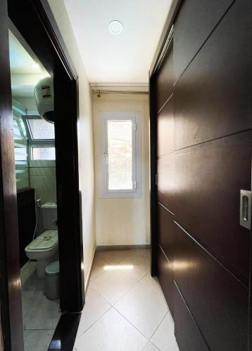 a bathroom with a toilet and a door with a window at Naama Inn Hotel in Sharm El Sheikh