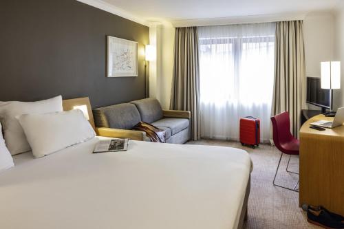 a hotel room with a bed and a couch at Novotel Bristol Centre in Bristol