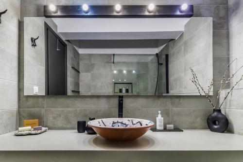 La salle de bains est pourvue d'un lavabo et d'un grand miroir. dans l'établissement Casa Naturale, à Skopelos