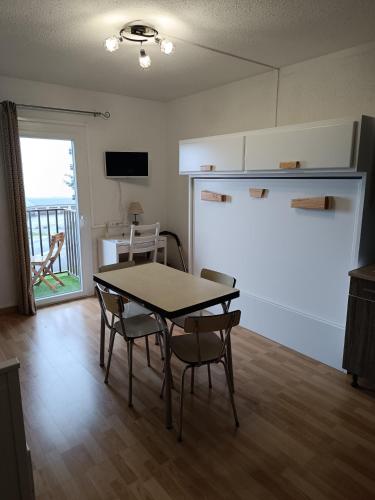 une cuisine et une salle à manger avec une table et des chaises dans l'établissement Studio agréable tout confort, aux Angles