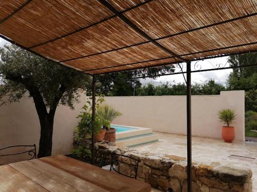 a patio with a wooden pergola and a swimming pool at Mazet A l Ombre des Z ' oliviers in Port-Sainte-Foy-et-Ponchapt