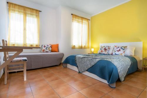 een slaapkamer met een bed, een bank en ramen bij Rainbow Guest House in Madalena