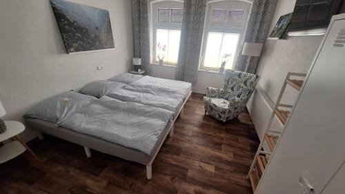 Un pequeño dormitorio con una cama y una silla. en Pauls Hexenhaus Wohnung Teufel mit Familienbett, en Thale