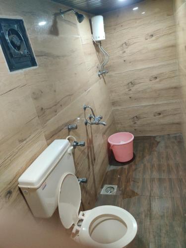 uma casa de banho com um WC e um balde rosa em PK Lodging em Ulhāsnagar