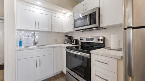 a kitchen with white cabinets and a stove top oven at Caloosa Cove Resort in Islamorada