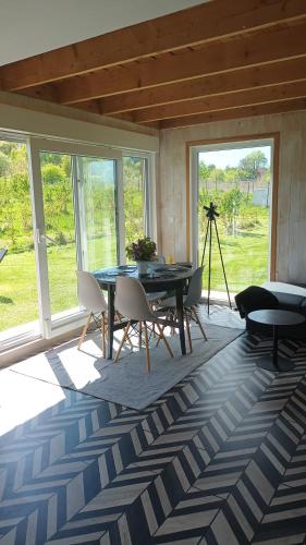 a living room with a table and chairs and windows at E Berry Farm - Slow life home in Olszyna