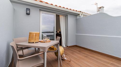 Apartamento pequeño con mesa y balcón. en Albergaria Quim Barreiros, en Vila Praia de Âncora