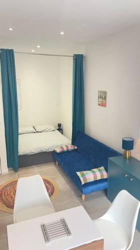 - un salon avec un lit et un canapé bleu dans l'établissement Studio à Sollies Pont, à Solliès-Pont