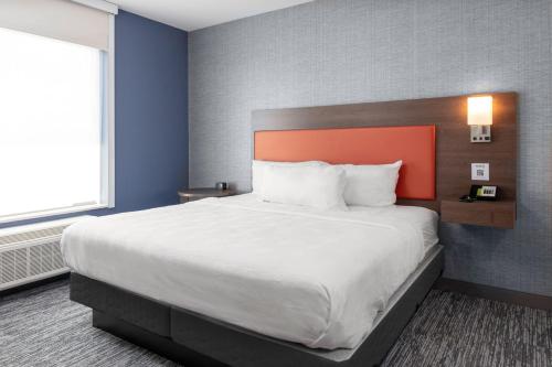 um quarto com uma cama grande e uma cabeceira laranja em Home2 Suites By Hilton Northville Detroit em Northville