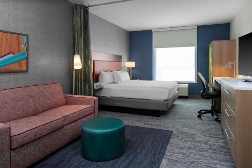 Habitación de hotel con cama y sofá en Home2 Suites By Hilton Northville Detroit, en Northville