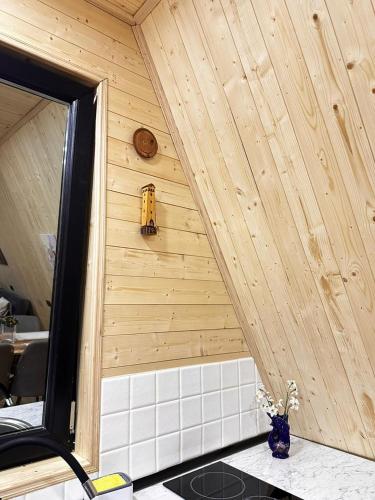 a room with a wood paneled wall and a mirror at Phaliani's Heaven in Mestia