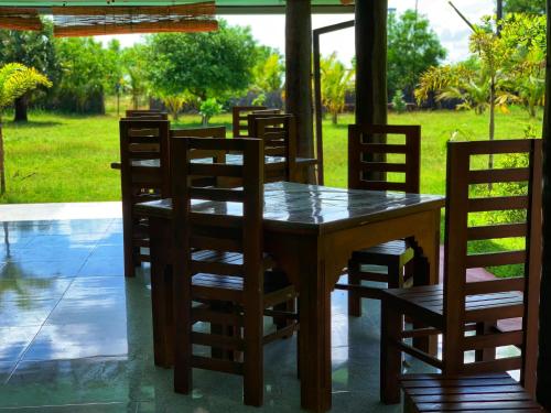 a wooden table and chairs in a yard at Greenbury Kite Hostel & Restaurant in Kalpitiya