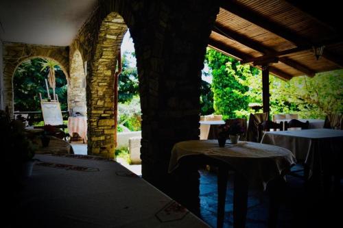 a room with two tables and a stone building at Hotel Paradise Ouranoupolis in Ouranoupoli