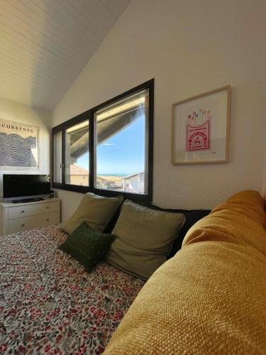 une chambre avec un lit et deux fenêtres dans l'établissement COSY & SURF : Confort et vue Mer à Seignosse Le Penon, à Seignosse