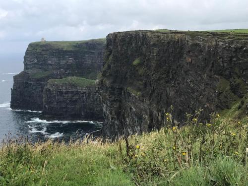 a large cliff next to a body of water at Cliffs of Moher Appartment in Liscannor