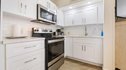 a kitchen with white cabinets and a black oven at Caloosa Cove Resort in Islamorada