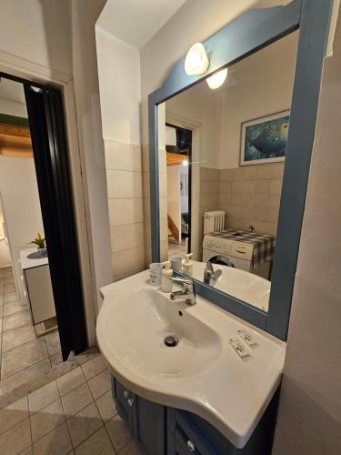 uma casa de banho com um lavatório e um espelho grande em La palazzina em Turim