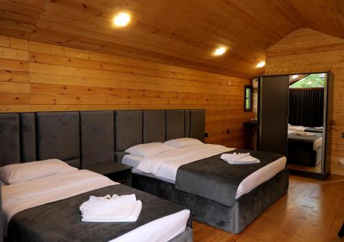 a bedroom with two beds in a wooden cabin at NICE HOUSE HOTEL Meghri in Meghri