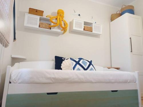 ein Schlafzimmer mit einem weißen Bett mit einem Seil an der Wand in der Unterkunft Erizana in Baiona